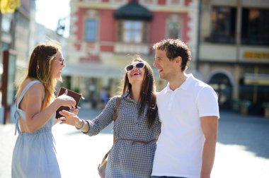 Üç genç insanlar antik kent meydanında stand.