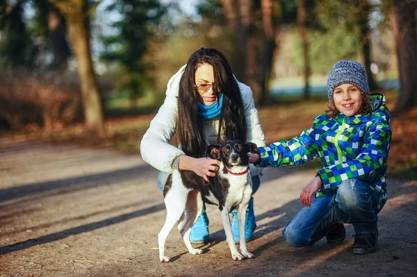 Moeder en zoon lopen hun huisdier in het najaar Park. — Stockfoto