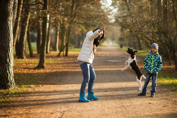 Madre e hijo pasean a su mascota en el parque de otoño . — Foto de Stock