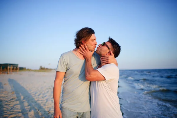Двое мужчин обнимаются на фоне моря . — стоковое фото