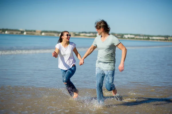 Gelukkige paar met blote voeten in het water. — Stockfoto