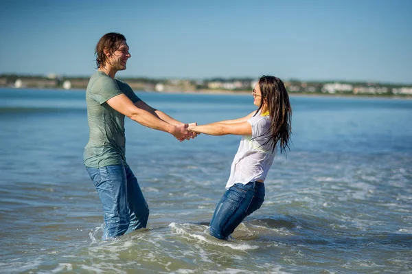 Gelukkige jonge paar dansen in de zee. — Stockfoto