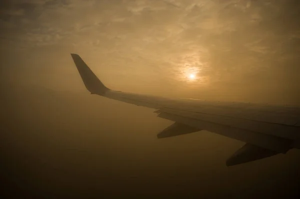 O sol atravessa as nuvens. Vista da janela do avião . — Fotografia de Stock