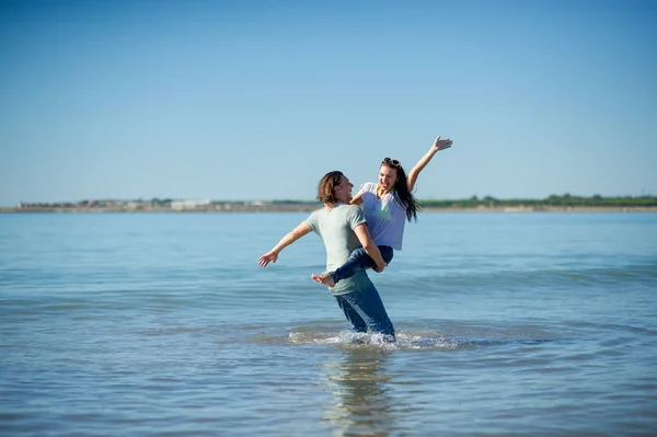 Gelukkige jonge paar dansen in de zee. — Stockfoto