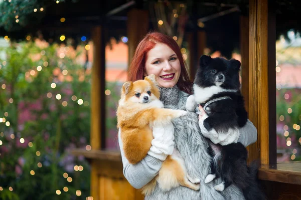 Mujer joven con dos mascotas en el bazar de Navidad . — Foto de Stock