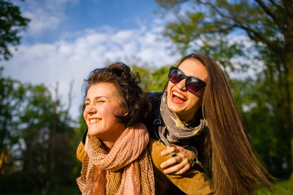 两位可爱的年轻女子在春天公园里高高兴兴地花时间 妇女有个好玩的心情 温暖阳光灿烂的日子 女朋友享受自然和通信 — 图库照片