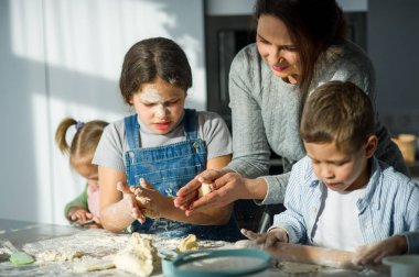 Anne çocuklarını yemek yapmayı öğretir..