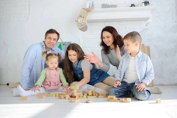 Parents play cubes with children. — Stock Photo, Image