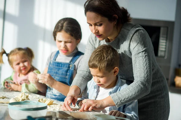 Mãe ensina seus filhos a cozinhar . — Fotografia de Stock