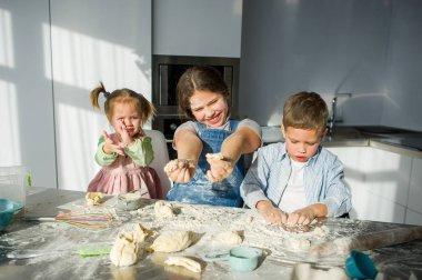 Üç çocukları hamur bir şey hazırlamak.