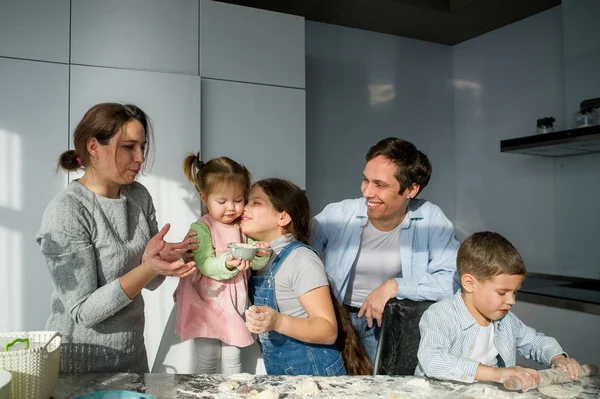 Groot gezin bereidt iets van deeg. — Stockfoto