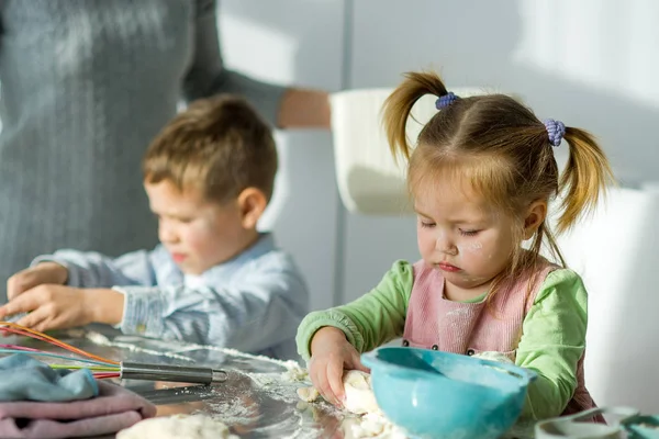 Dos niños están cocinando algo de la masa . Imágenes de stock libres de derechos