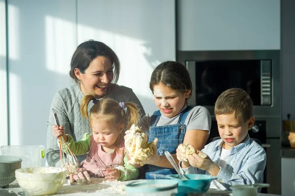 Matka Uczy Troje Dzieci Gotować Rodzina Przygotowuje Coś Ciasta Stole — Zdjęcie stockowe