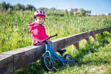 Kız kros bisikletine bindikten sonra dinlenmek için oturdu.