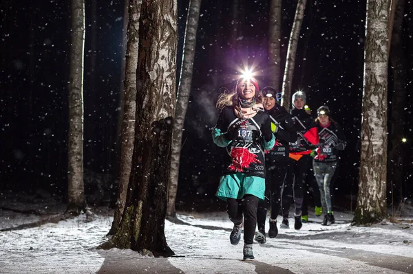 运动员们在树林里沿着跑道奔跑 Sosnovka公园夜间比赛 Shatun Trail 2020 图库图片