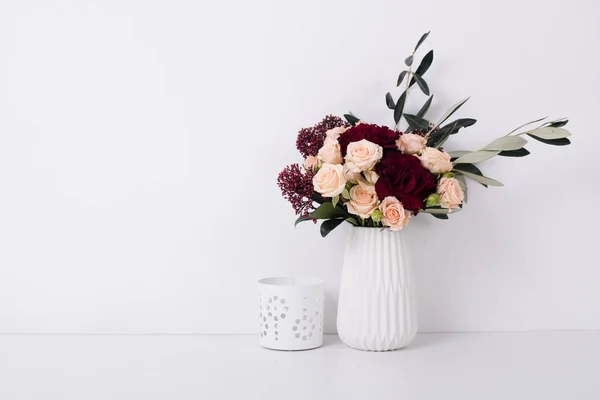 Roses et oeillets dans un vase à l'intérieur blanc — Photo