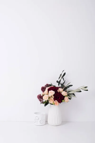 Roses et oeillets dans un vase à l'intérieur blanc — Photo