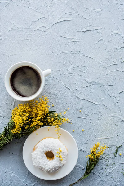 Kopje koffie en een donut op concrete achtergrond — Stockfoto