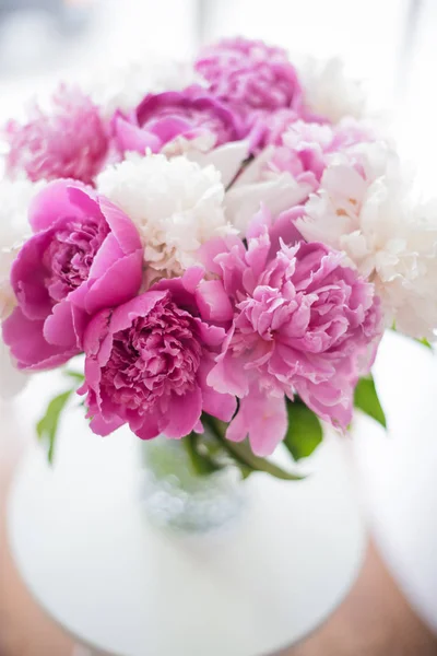 Decoración casera, peonías rosadas frescas en la mesa de centro en roo blanco —  Fotos de Stock