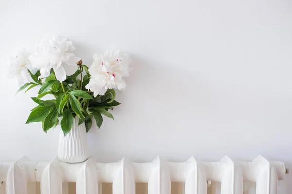 Huis decoratie, verse pioenrozen in witte gezellige kamer interieur met — Stockfoto