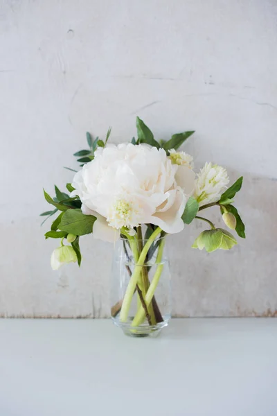 Bílá Pivoňka květiny na konferenční stolek v bílé místnosti interiéru, cele — Stock fotografie