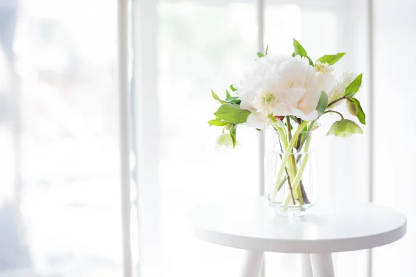 Bílá Pivoňka květiny na konferenční stolek v bílé místnosti interiéru, cele — Stock fotografie