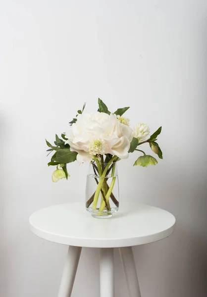 Fleurs pivoine blanche sur la table basse à l'intérieur de la chambre blanche — Photo