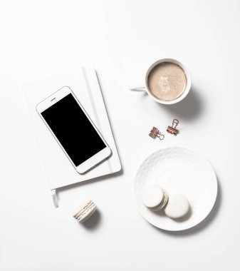 Beyaz kadınsı düz bej macaroons, kahve ve smartph lay