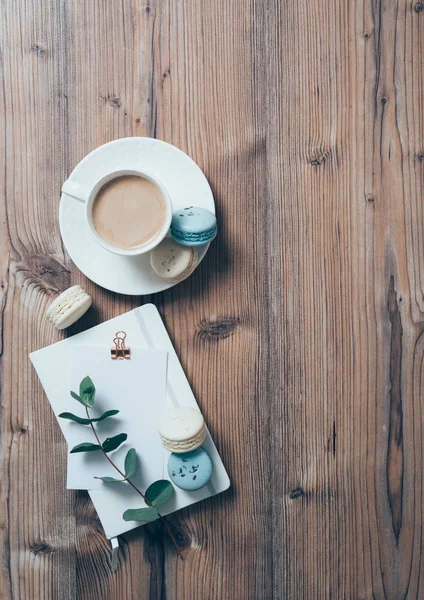 Чашка кави і сині макаруни на дерев'яному фоні столу — стокове фото