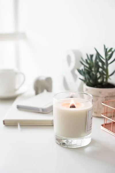 Bílá hořící svíčka na stole, domácí dekorace interiéru — Stock fotografie