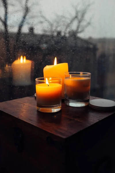Üç yanan mumlar masaya, rahat yağmurlu gün bir ev — Stok fotoğraf