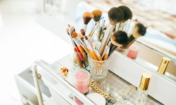 Make-up penselen en cosmetische op kaptafel — Stockfoto