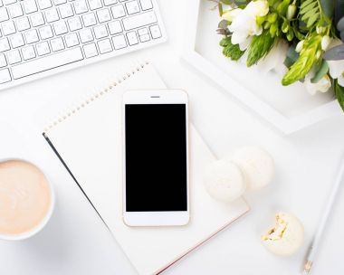 Taze kokulu çiçek ve macaro Bayan blogcular çalışma masası