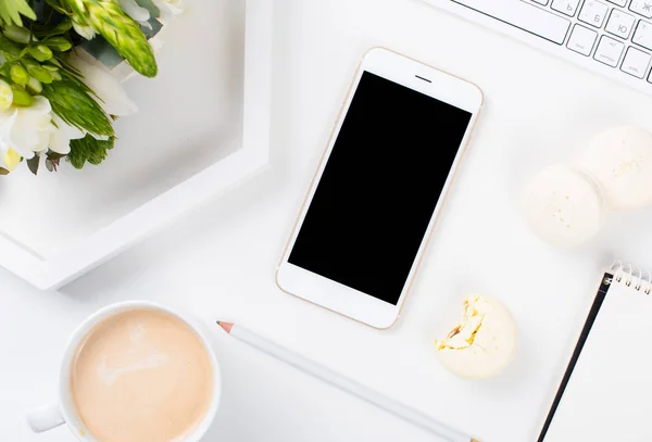 Bloggerinnen Schreibtisch mit frischem Blumenstrauß und Makaro — Stockfoto