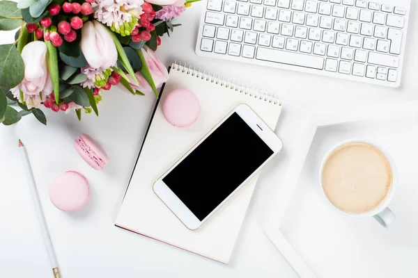 Lady bloggers work desk with pink flowers and macaron cakes on w — Stock Photo, Image
