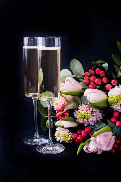 Two glasses of champagne and bouquet of pink flowers — Stock Photo, Image