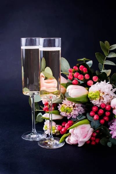 Two glasses of champagne and bouquet of pink flowers — Stock Photo, Image