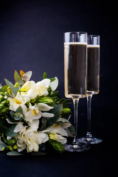 Two glasses of champagne and bouquet of white flowers — Stock Photo, Image