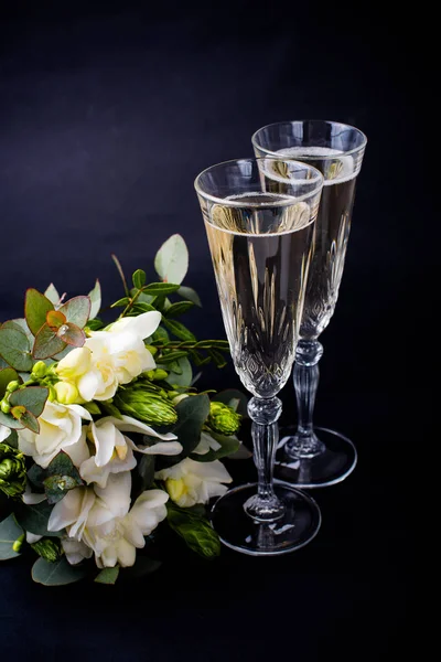 Two glasses of champagne and bouquet of white flowers — Stock Photo, Image