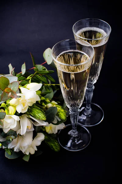 Two glasses of champagne and bouquet of white flowers — Stock Photo, Image