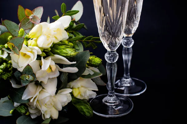 Two glasses of champagne and bouquet of white flowers — Stock Photo, Image