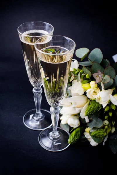 Two glasses of champagne and bouquet of white flowers — Stock Photo, Image