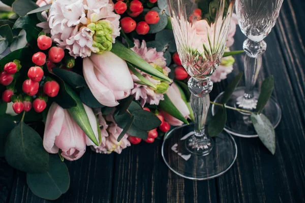 Dvě sklenice šampaňského a růžové kytici na tmavém woo — Stock fotografie