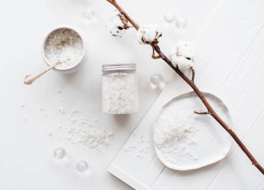 Beyaz bir arka plan üzerinde kozmetik deniz tuzu ve pamuk çiçek
