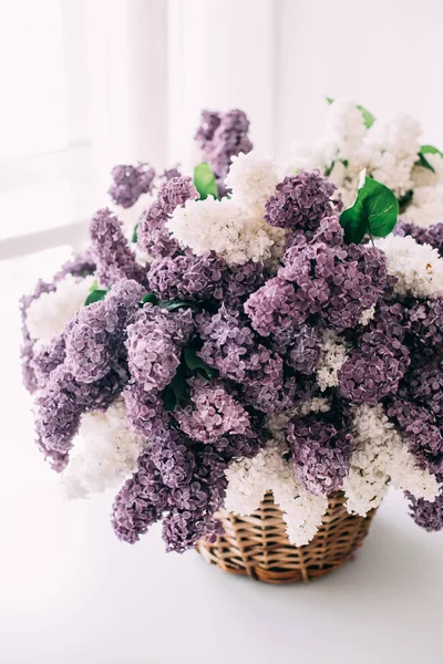 Ramo de flores de color lila blanco y púrpura en canasta de mimbre en ta — Foto de Stock