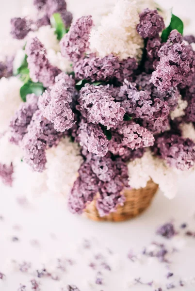 Csokor fehér és lila lila virágok fonott kosár, a ta — Stock Fotó