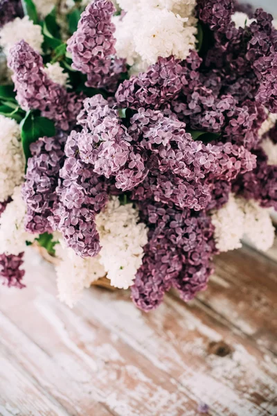 Boeket van wit en paars lila bloemen in rieten mand op ta — Stockfoto