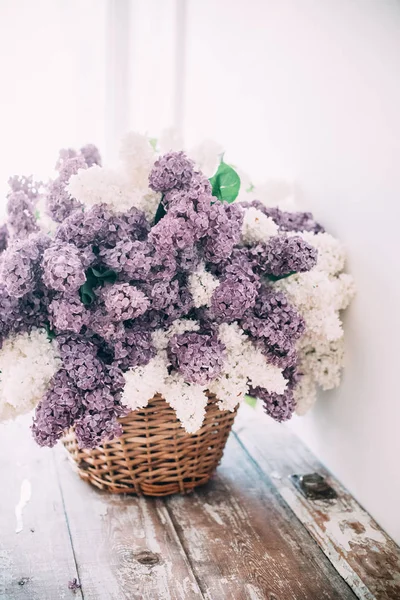 Ramo de flores de color lila blanco y púrpura en canasta de mimbre en ta — Foto de Stock