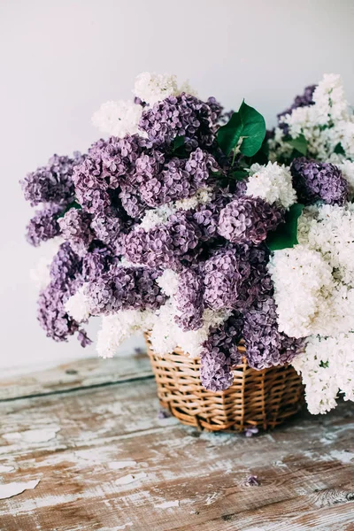 Bouquet di fiori lilla bianchi e viola in cesto di vimini su ta — Foto Stock
