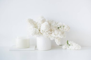 Minimalist beyaz ev dekorasyonu, Cam vazo içinde sunulan taze leylak çiçek buketi